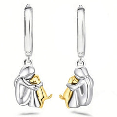 A little girl and a dog embrace earrings